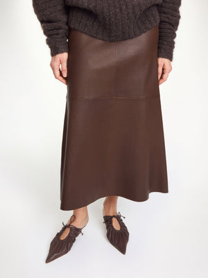 Fashion view of the Simoas Leather Skirt in Carafe paired with a bohemian blouse, showcasing its elegant silhouette and luxury design.