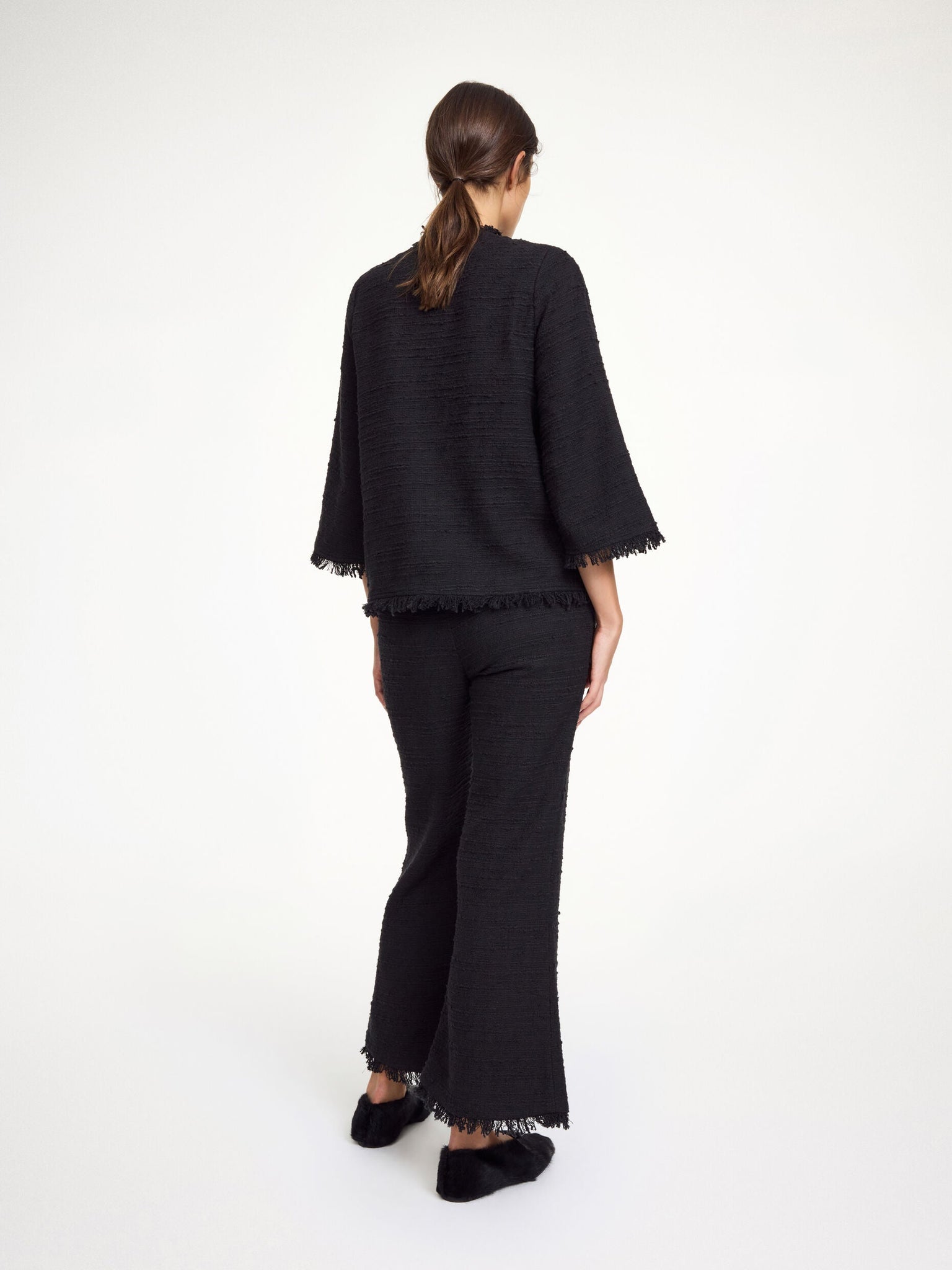 Model wearing the Diana Boucle Blouse in Black paired with coordinating Mafaldana Boucle trousers for a stylish outfit.