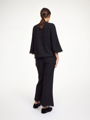 Model wearing the Diana Boucle Blouse in Black paired with coordinating Mafaldana Boucle trousers for a stylish outfit.