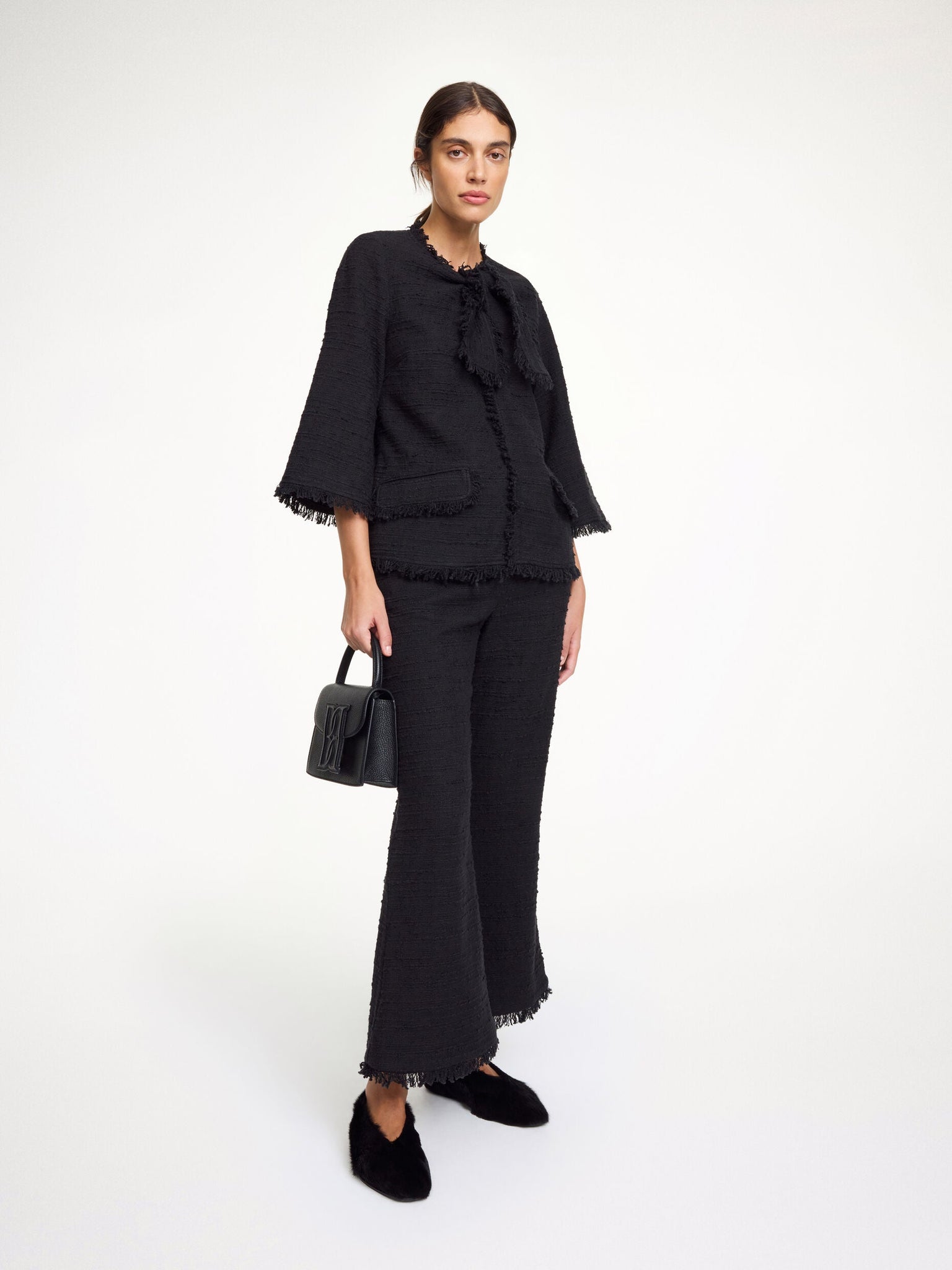 Close-up of the Diana Boucle Blouse in Black, showcasing the lady-like front tie and textured cotton mix fabric.