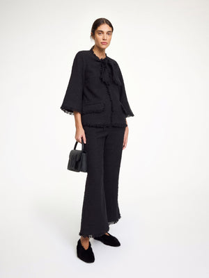 Close-up of the Diana Boucle Blouse in Black, showcasing the lady-like front tie and textured cotton mix fabric.