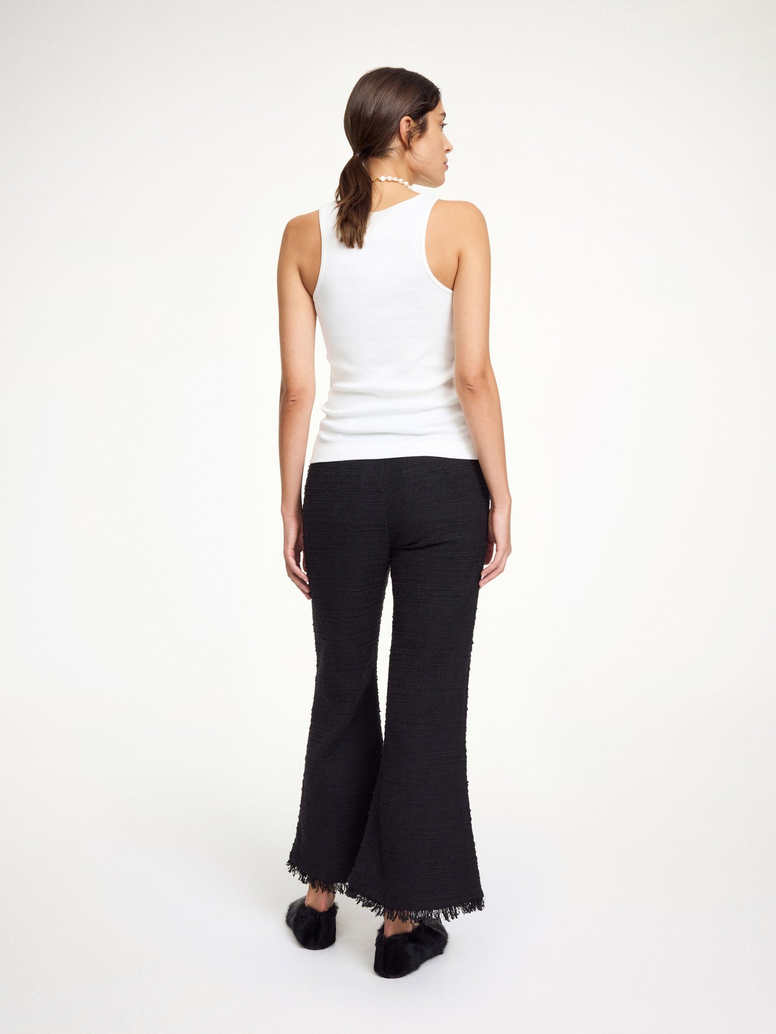 Back view of Mafaldana Boucle Trousers in Black showing the zip, hook, and button closure.