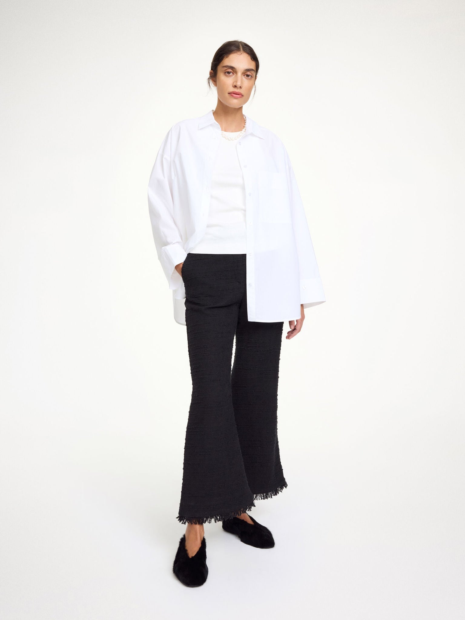 Close-up of the Mafaldana Boucle Trousers in Black highlighting the tactile fabric and fringe hems detail.