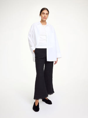 Close-up of the Mafaldana Boucle Trousers in Black highlighting the tactile fabric and fringe hems detail.