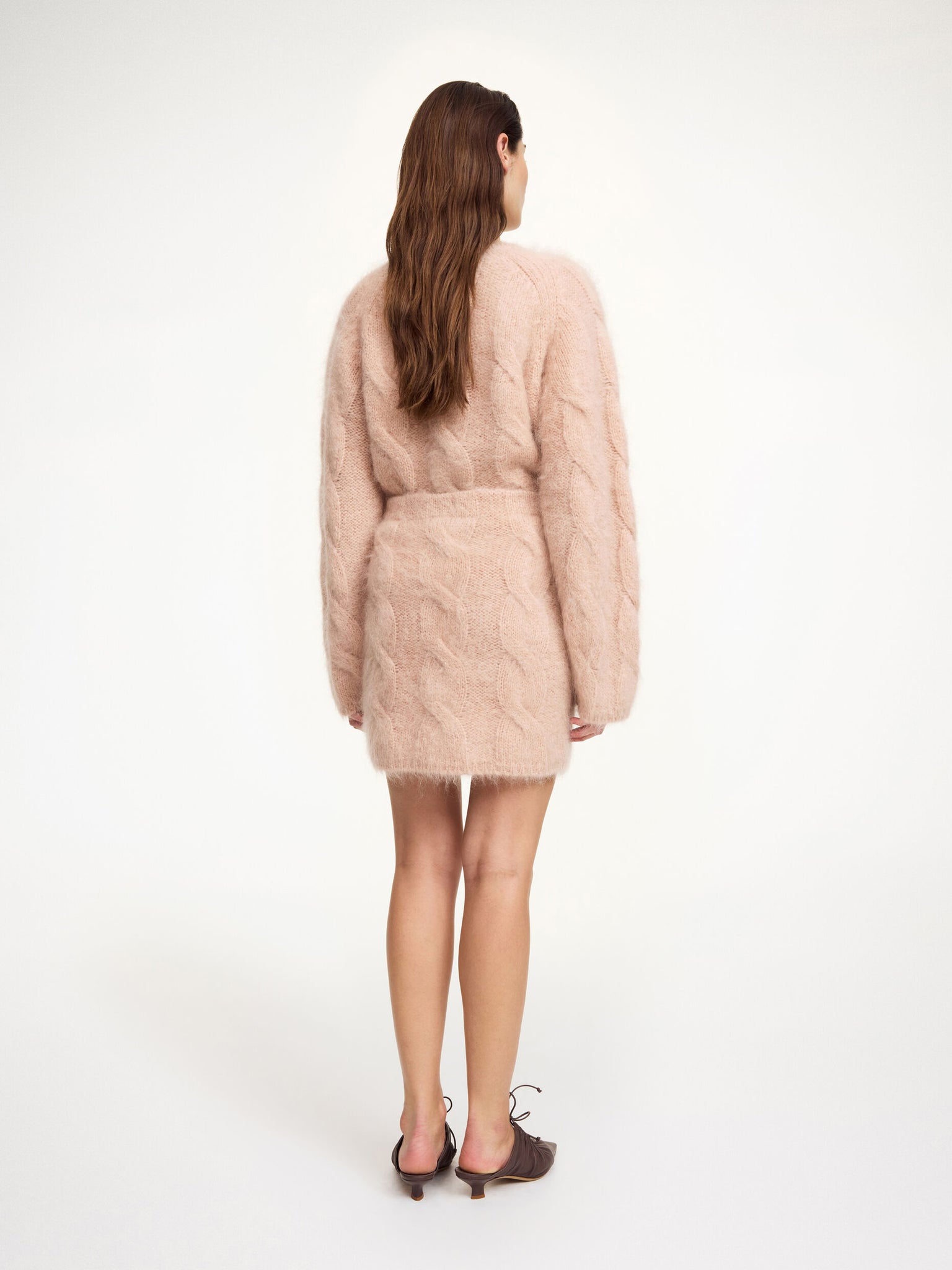 Model wearing the Eliotta Mini Skirt in Rose Dust styled with the coordinating Elliot sweater for a chic winter look.