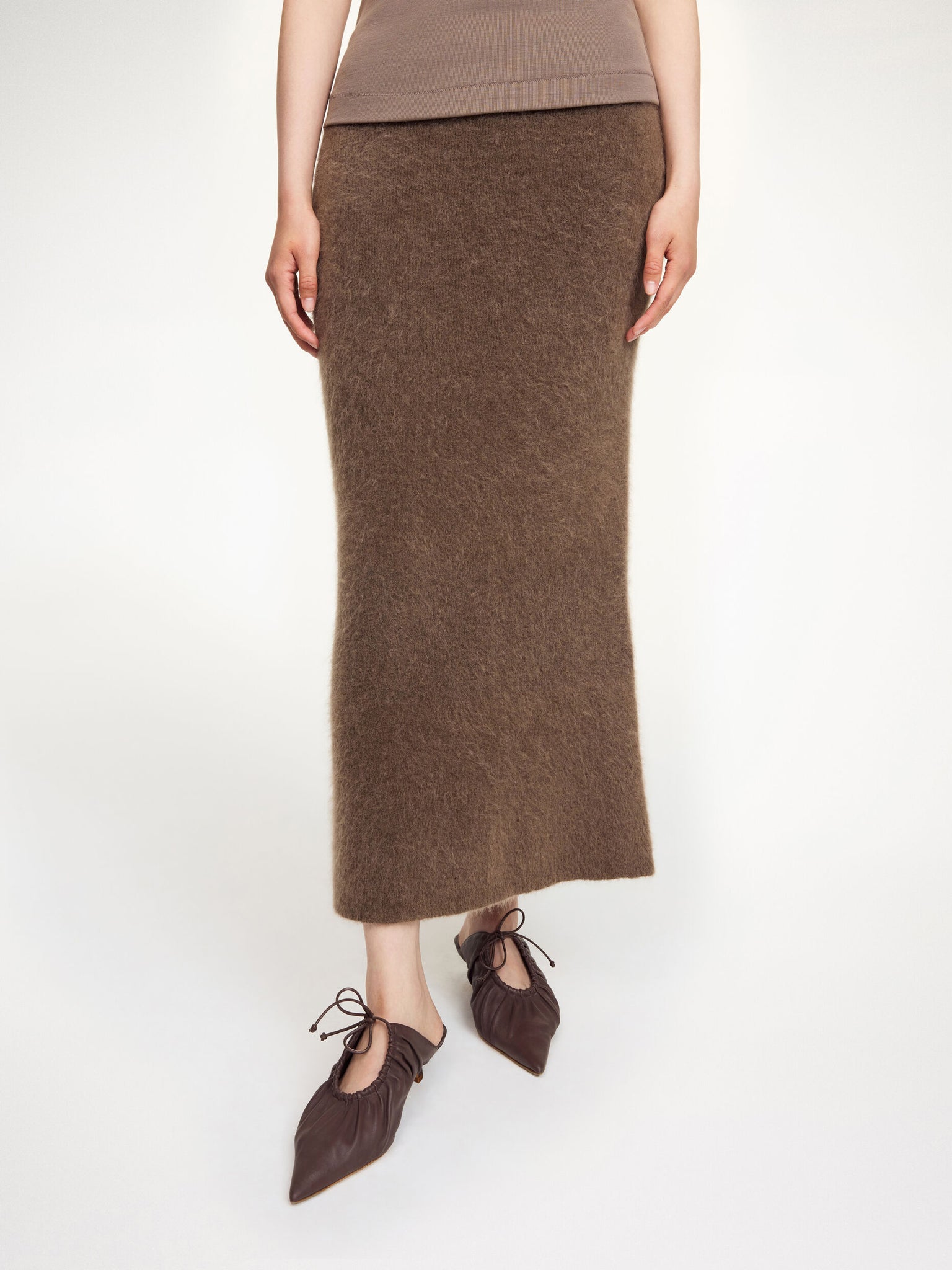 View of the Estille Skirt in Chocolate Chip by By Malene Birger displayed on a hanger, highlighting its minimalistic design.