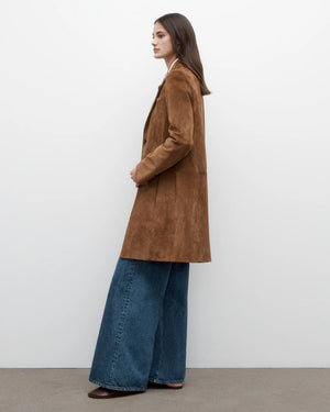 The Easy Car Coat in Martora hanging on a rack, emphasizing its long sleeves and button cuffs.