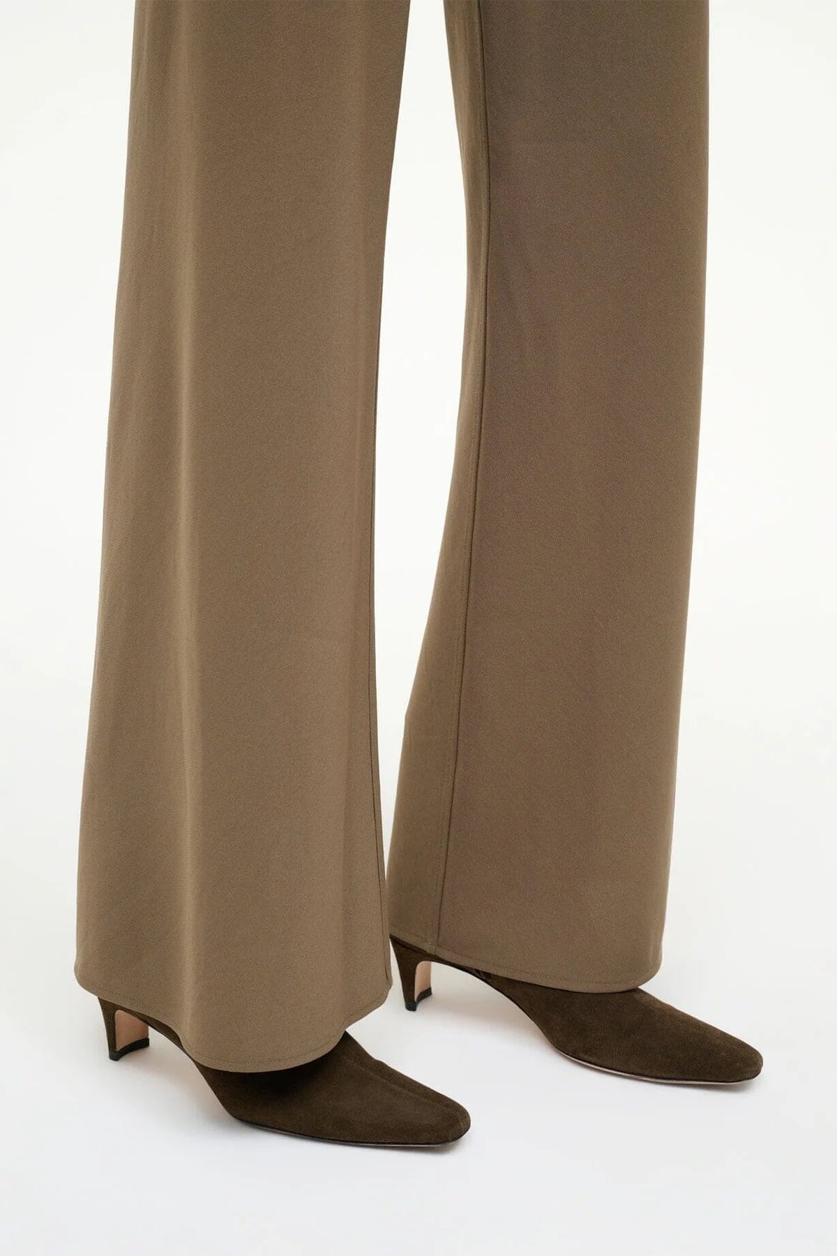 Wally Ankle Boot in Truffle Suede with a stylish backdrop, highlighting its blade heel.