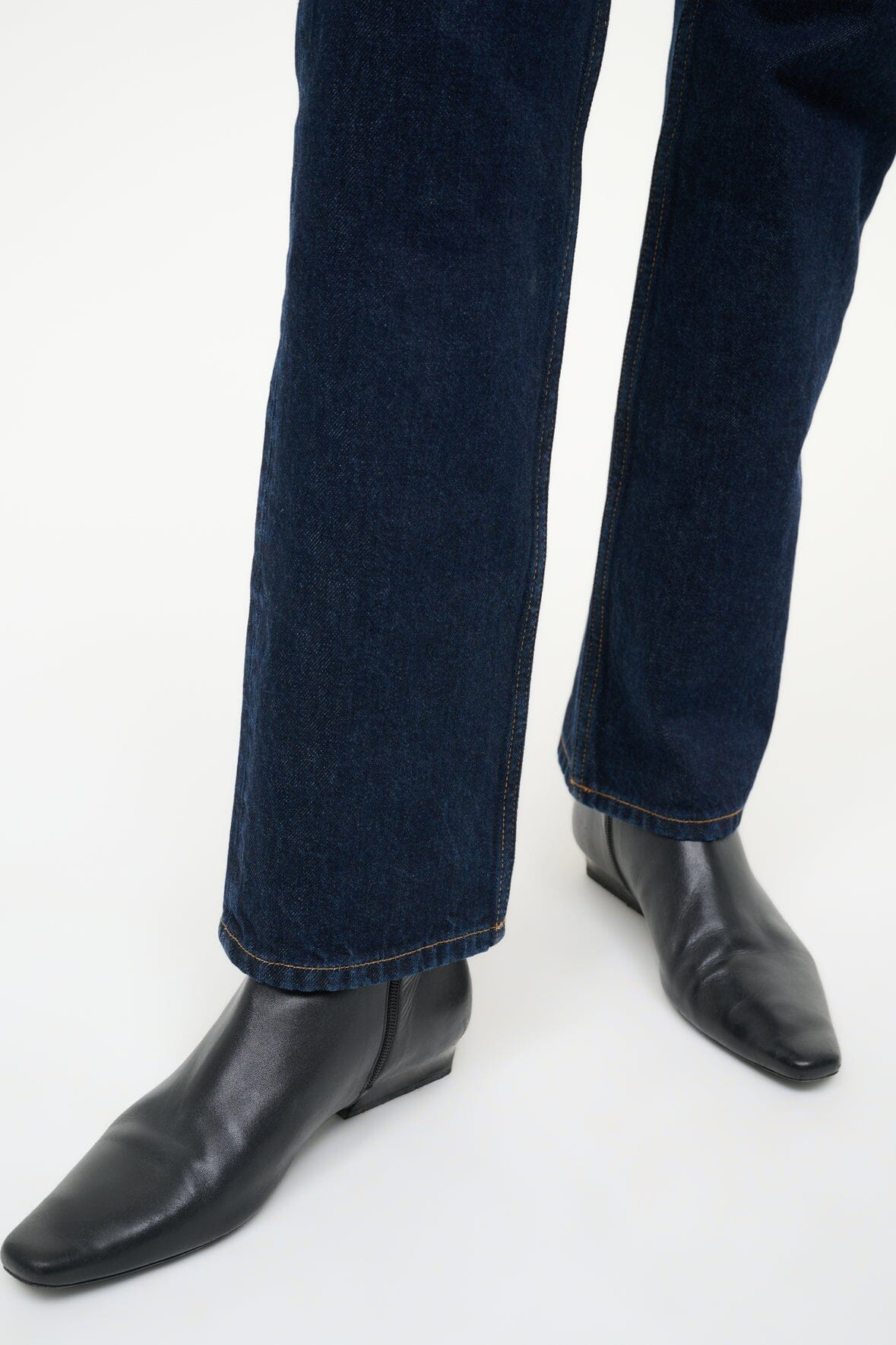 Wally Flat Ankle Boot in Black on a model, showcasing how to style it for a trendy look.