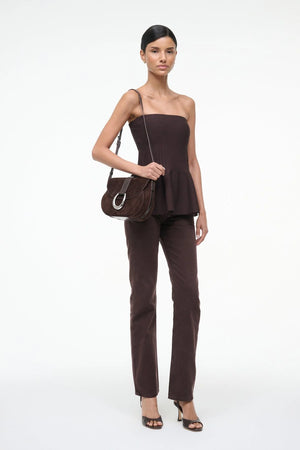 Fashion model wearing the Staud Evie Top in Earth, highlighting its compact tube style.