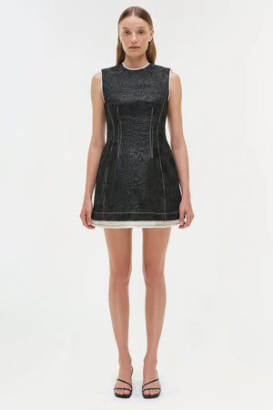 Close-up of the fabric texture of the Audrina Jacquard Mini Dress in Black, showcasing its unique waxed jacquard design.