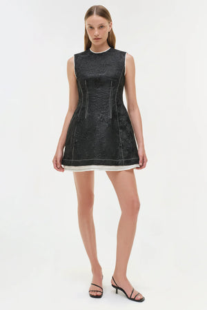 Side angle of the Audrina Jacquard Mini Dress in Black, emphasizing the contrast stitching and structured style.