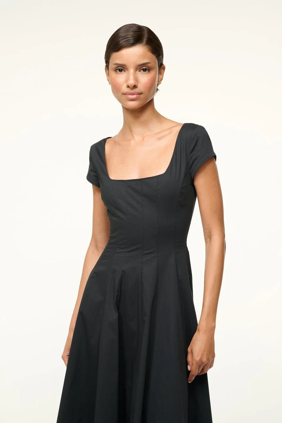 Short Sleeve Wells Dress in Black styled with accessories on a minimalist background.