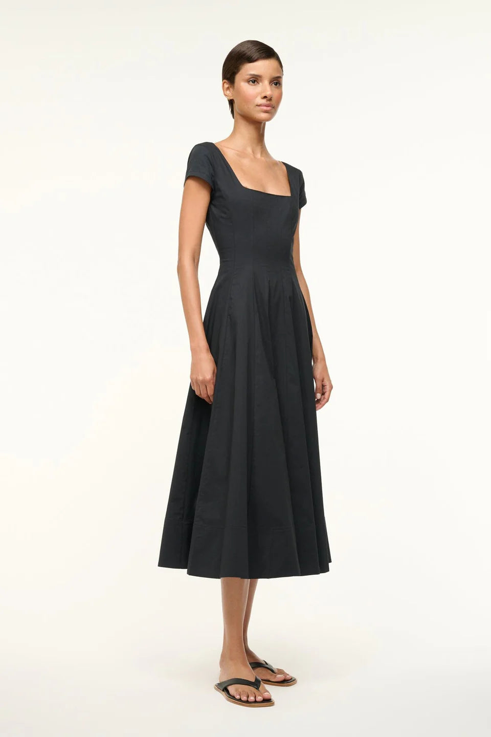 Model wearing the Short Sleeve Wells Dress in Black, showcasing its a-line skirt.