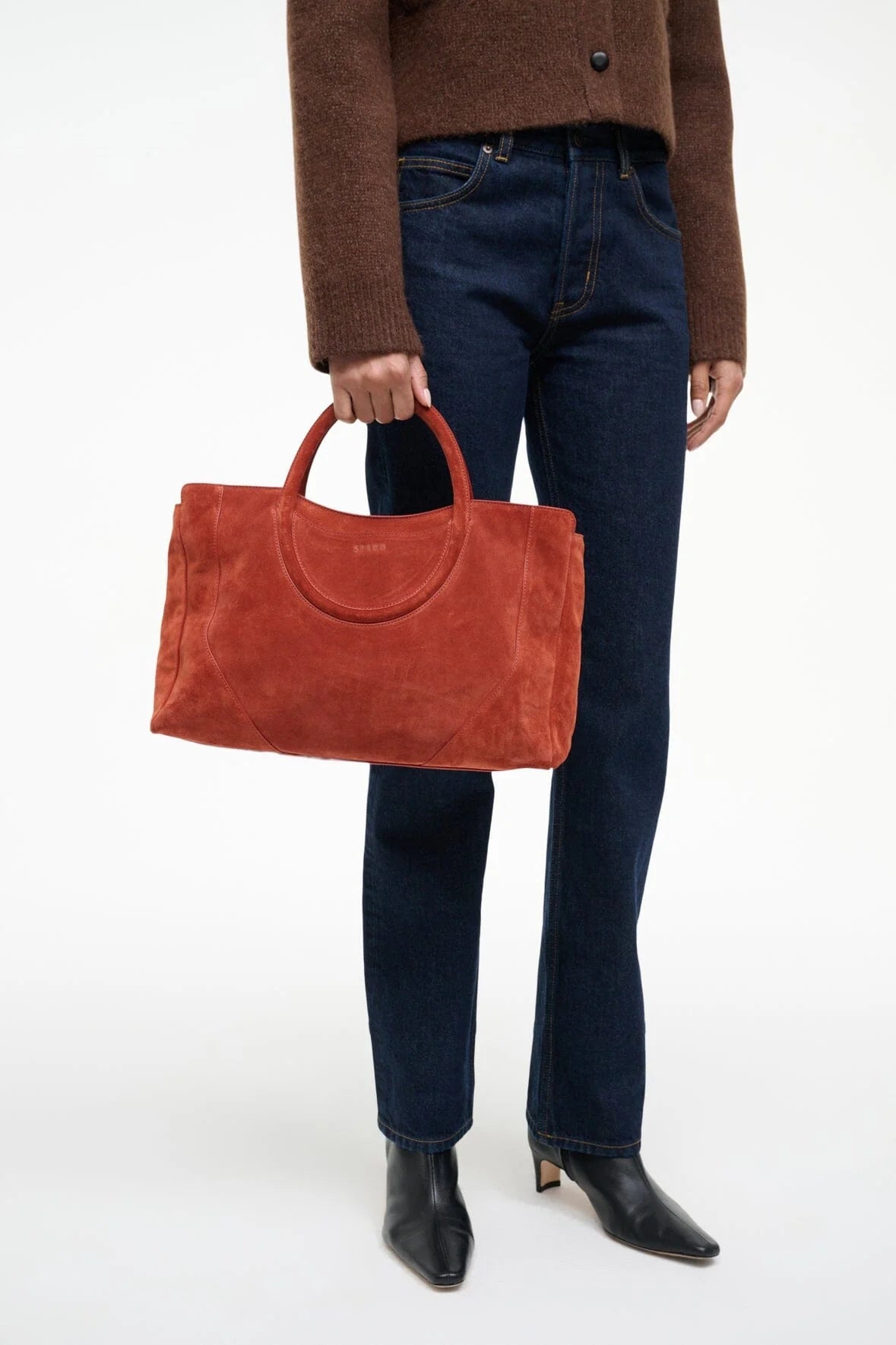 Chic Maude Satchel in Auburn Suede being held by a model.