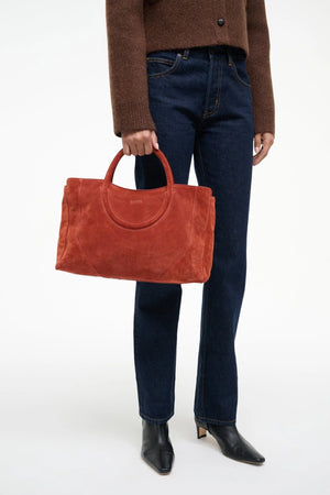 Chic Maude Satchel in Auburn Suede being held by a model.