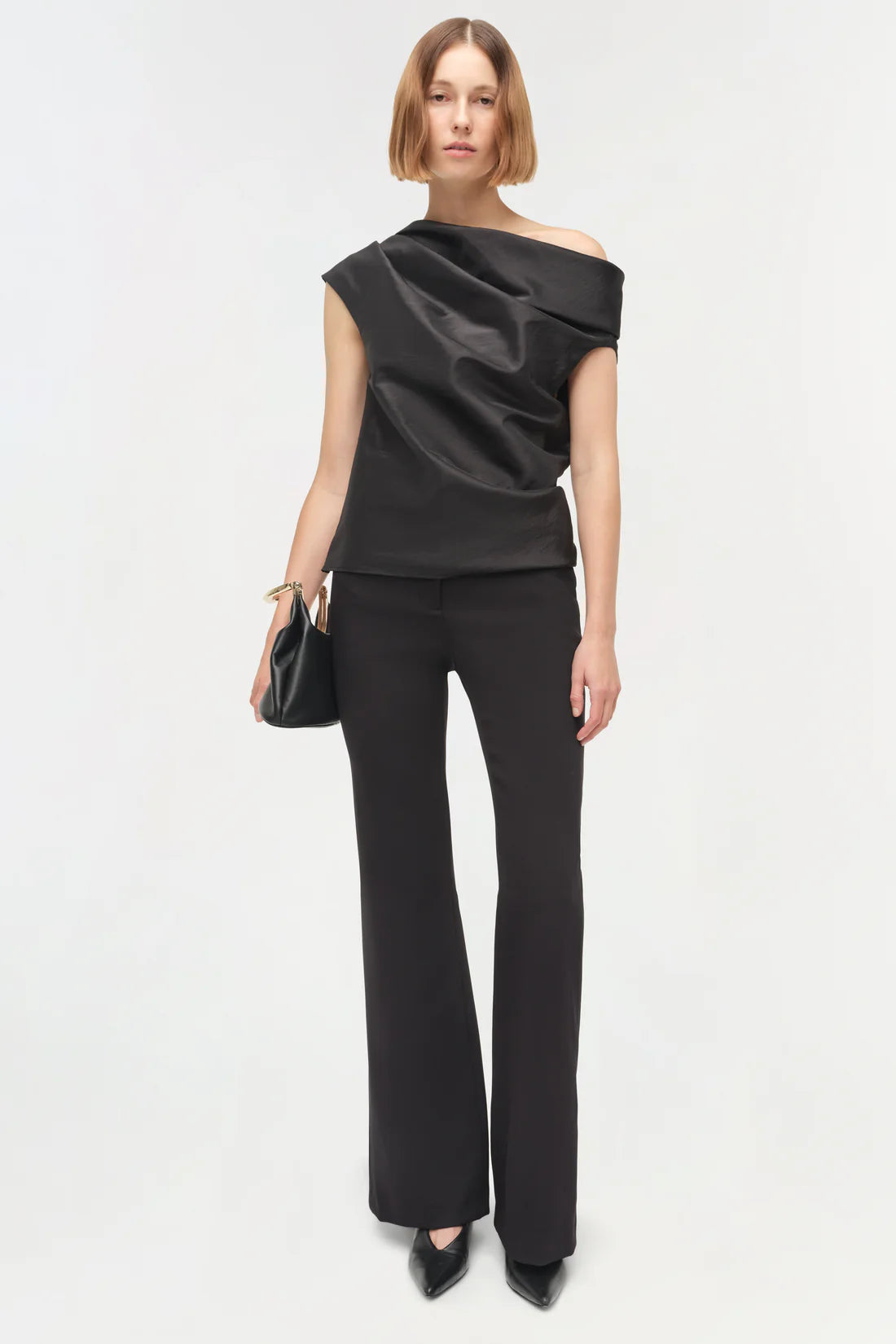 Detail shot of the shoulder of the Vivia Taffeta Draped Top in Black, featuring its distinctive draped design.