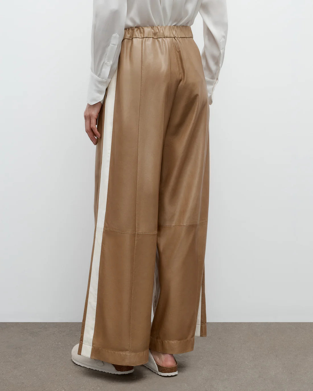 Side view of Eva with Tux Pant in Kelp/Bone, emphasizing the wide leg design and inverted pleats.