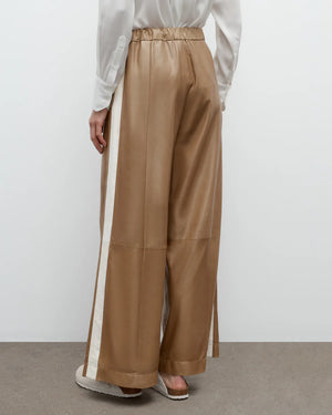 Side view of Eva with Tux Pant in Kelp/Bone, emphasizing the wide leg design and inverted pleats.