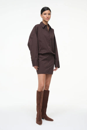 Model wearing the Cynthia Dress in Earth by Staud, beautifully styled with long sleeves and a mini skirt for a chic look.