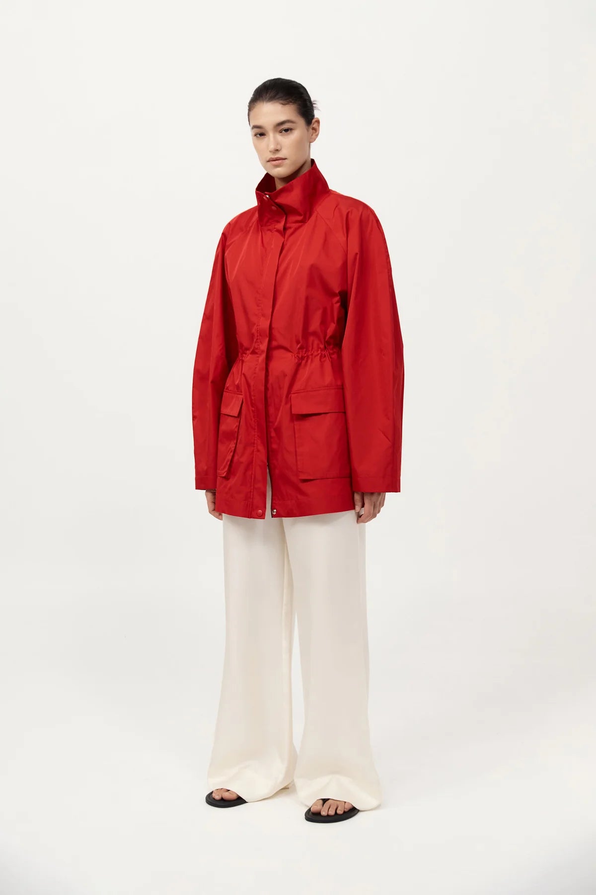 Model wearing St. Agni's Paper Taffeta Parka in Red, demonstrating its adjustable internal drawcord waist.