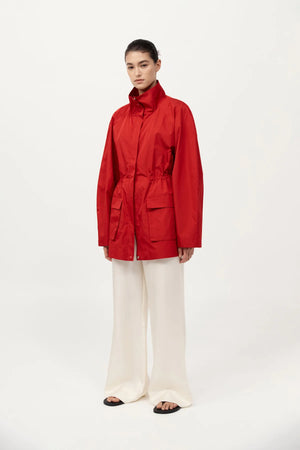 Model wearing St. Agni's Paper Taffeta Parka in Red, demonstrating its adjustable internal drawcord waist.