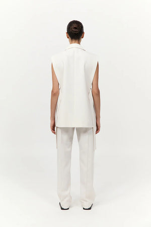 Model wearing the Relaxed Side Tie Vest in Off White paired with twill wide leg pleat pants by St. Agni.