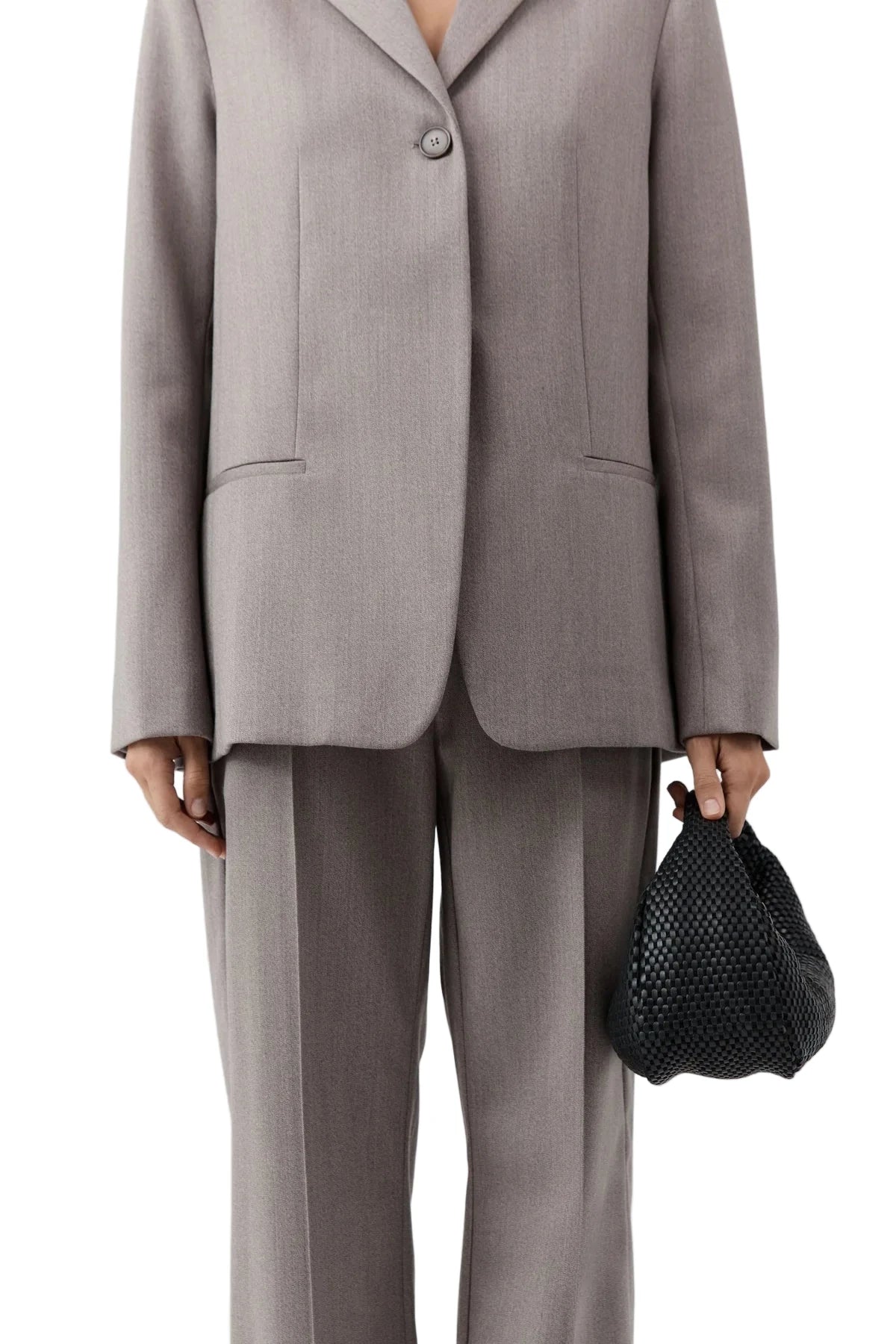 St. Agni's Lattice Weave Bon Bon Bag in Black worn as a stylish clutch, adding sophistication to casual looks.