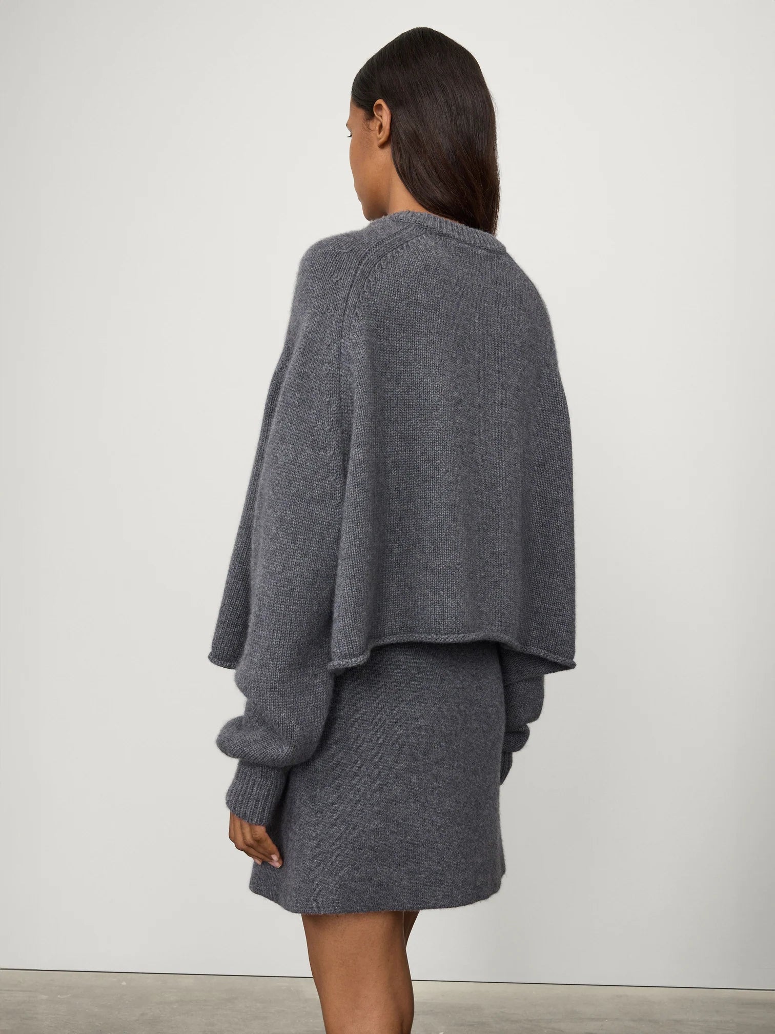 Back view of the Karine Sweater in Graphite, featuring a rolled hem and soft draping.