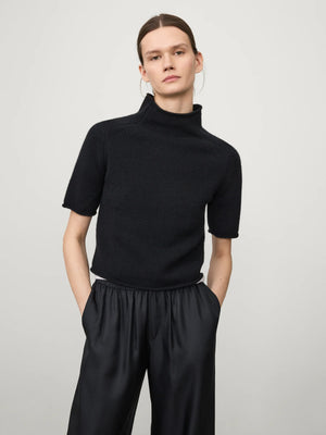 Model wearing the Fride Sweater in Black by Lisa Yang, demonstrating its regular fit and slim short sleeves.