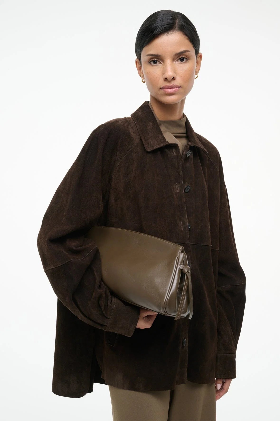 The elegant Maude Soft Clutch in Truffle displayed with a beautiful knotted tie detail on the sides.