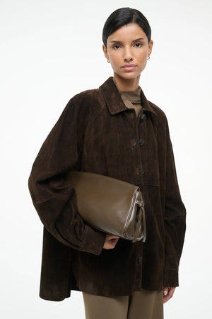 The elegant Maude Soft Clutch in Truffle displayed with a beautiful knotted tie detail on the sides.
