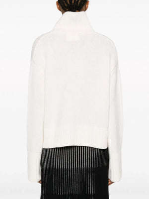 Model wearing the Fleur Sweater in Cream, styled for a chic casual outfit.