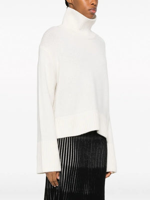 Back view of the Fleur Sweater in Cream, featuring ribbed cuffs and hem for a stylish look.