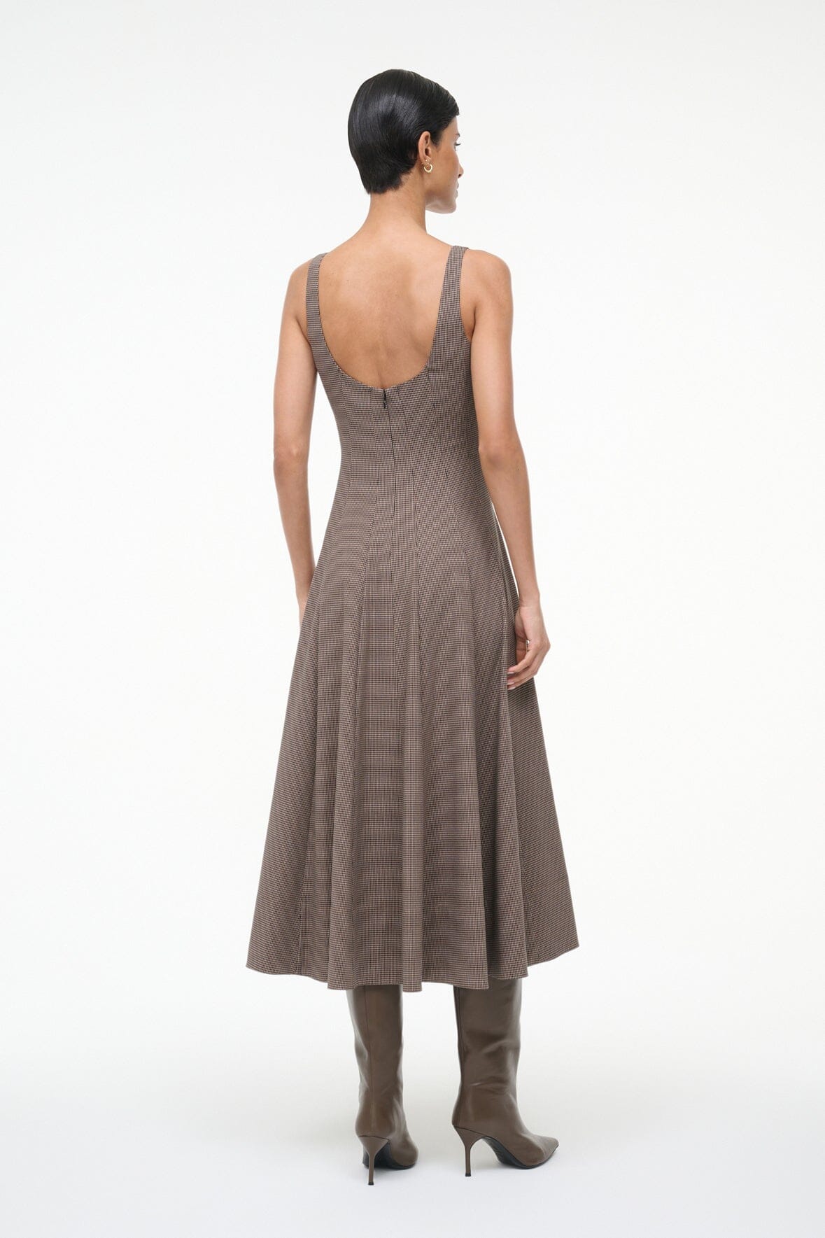 Woman wearing the Staud Wells Dress in Houndstooth, highlighting its flattering fitted shape