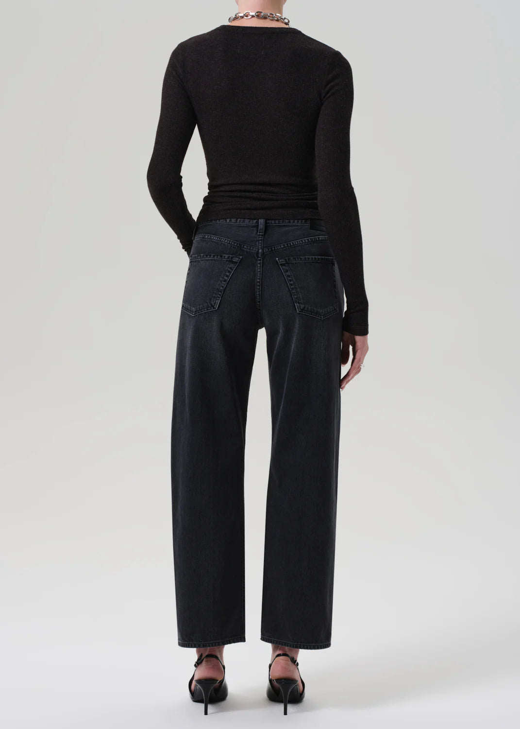 Woman wearing Lindz Easy Straight jeans in Vintage Black paired with stylish boots, demonstrating versatility.
