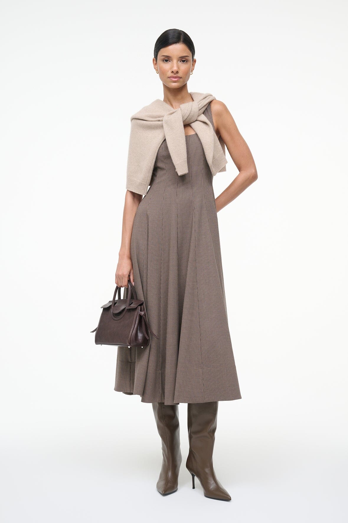 Staud Wells Dress in Houndstooth displayed on a hanger, emphasizing the unique fabric composition and style