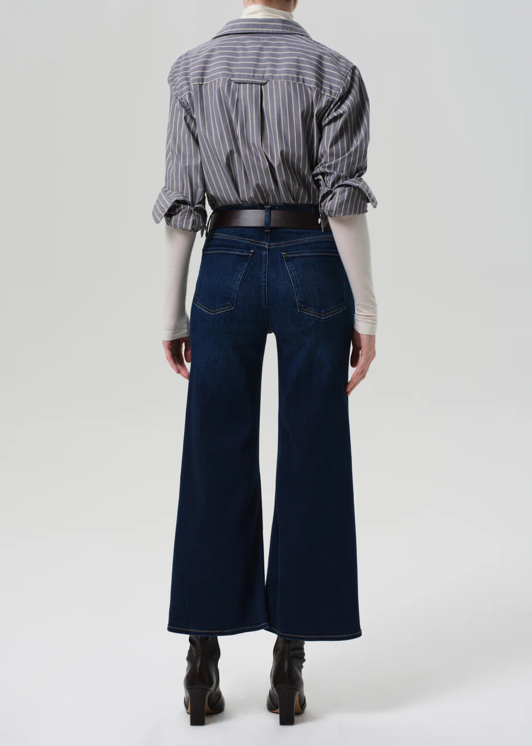 A stylish model wearing the Citizens of Humanity Lyra Crop Wide Leg in Dakota, paired with sneakers for a casual look.