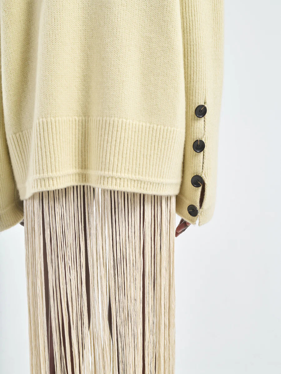 The Primrose Yellow Button Mock Neck Sweater displayed against a stylish backdrop.