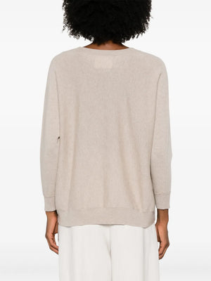Kenny Sweater in Sand draped casually over shoulders, demonstrating its versatility and relaxed fit.