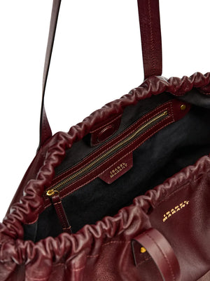 Functional shot of the Silven E/W Bag in Burgundy, highlighting its size and luxurious lambskin material.