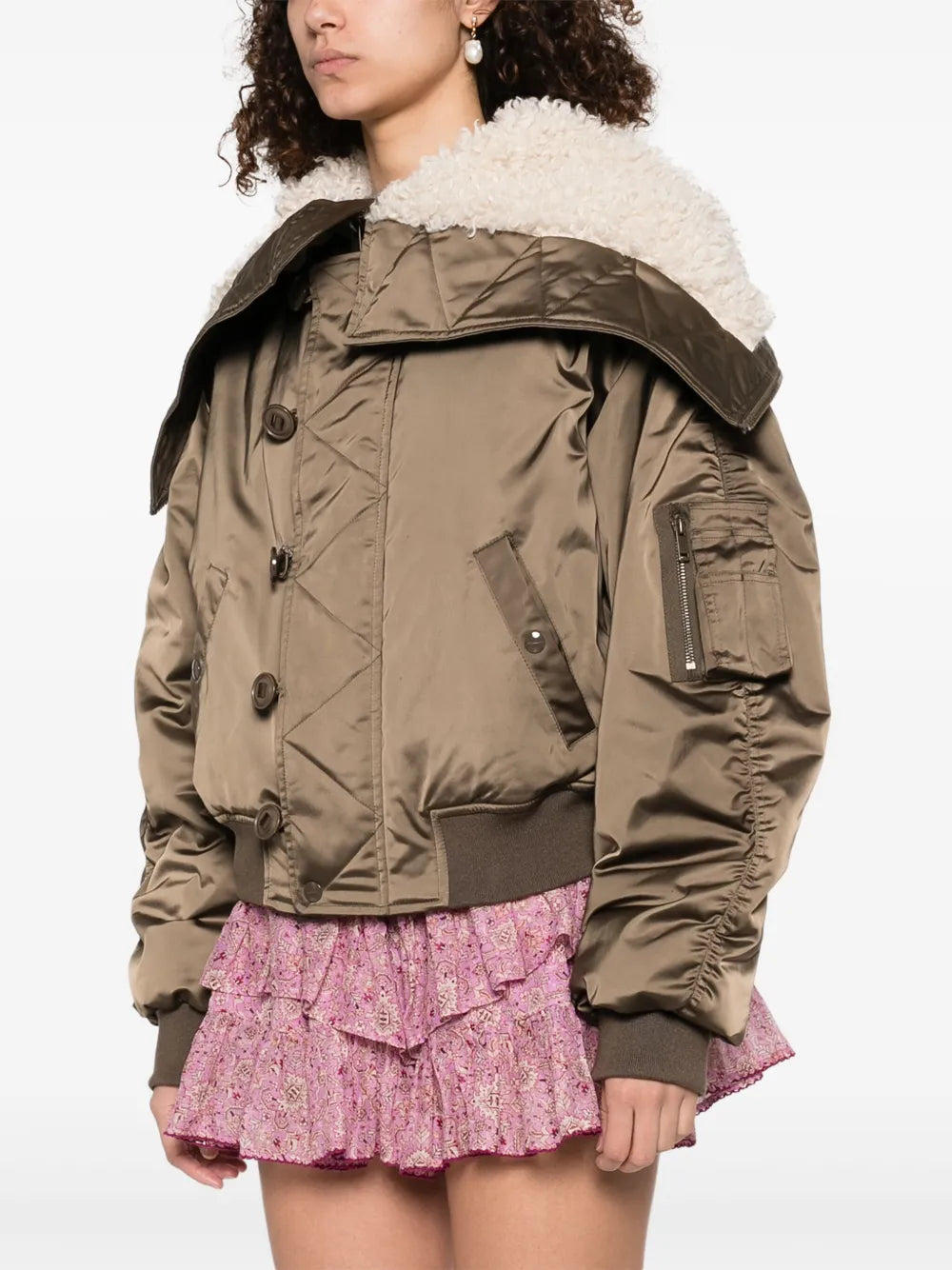 Profile view of the Elisa Coat in Khaki, featuring gathered sleeves and zippered patch pockets.