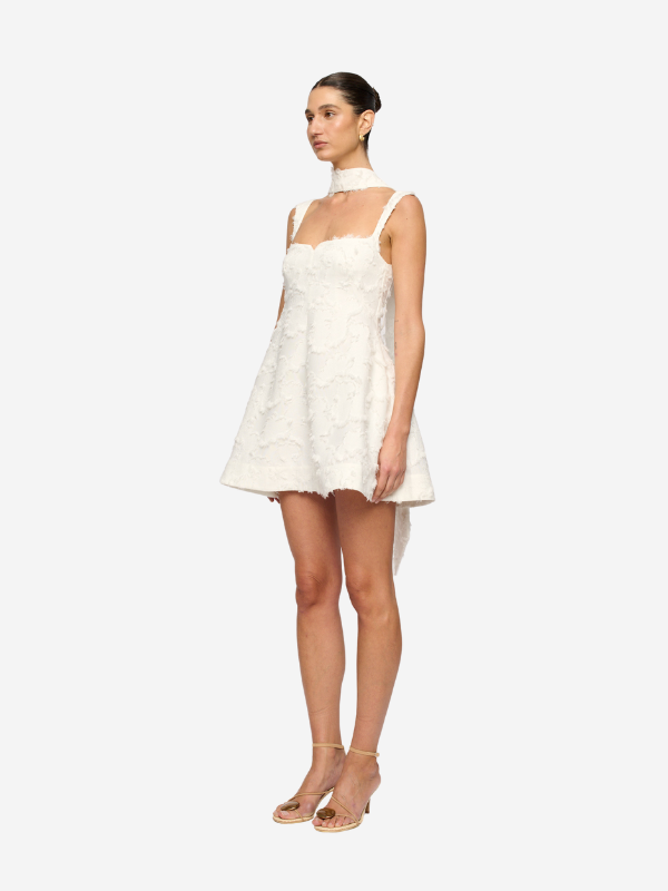 Close-up detail of the Rue Jacquard Mini Dress in White highlighting the structured mini-length skirt.