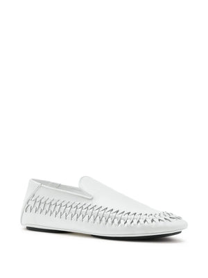 Close-up of the Proenza Schouler Whip Loafer in Ecru highlighting the rounded tongue and embossed monogram.