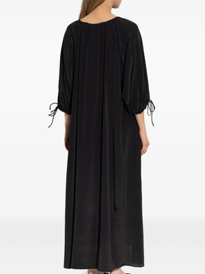 Model wearing the Lily Dress in Black by By Malene Birger, styled for a summer day, showing versatility in styling.