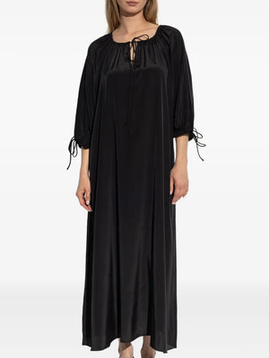 Full view of the Lily Dress in Black by By Malene Birger, displaying its airy design and elegant silhouette.