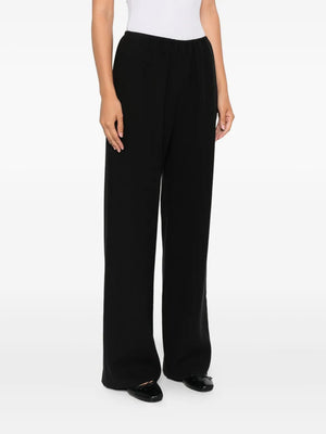 The Nanushka Arvenn Pants in Black displayed flat against a neutral backdrop, showcasing the relaxed fit and high-rise waist.