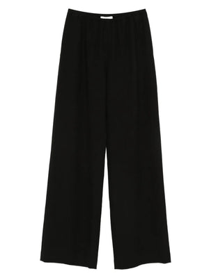 Nanushka Arvenn Pants in Black showcased on a model, exuding elegance with a high-rise style and relaxed legs.
