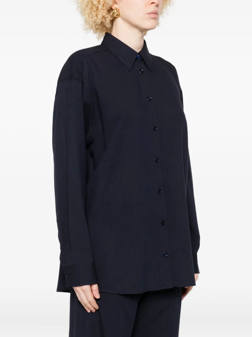 Model wearing the Fluid Classic Shirt in Navy by TOTEME, styled over a simple tee.