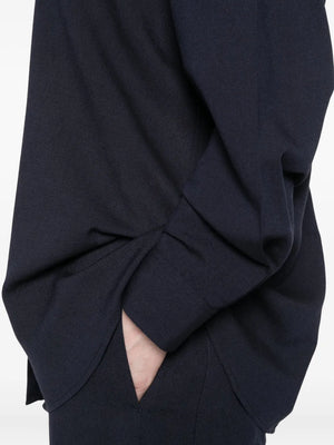 Fluid Classic Shirt in Navy by TOTEME presented on a hanger, emphasizing its fluid viscose-wool blend.